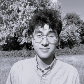 Foto dell'autore in bianco nero. Sullo sfondo, un albero in un parco.